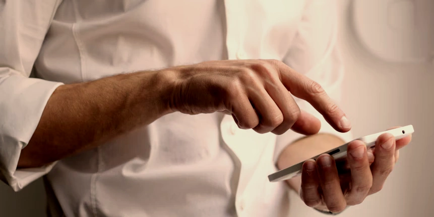 View of the hands of a person dialing a smartphone