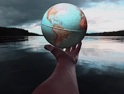 Globe held at arm's length at the water's edge